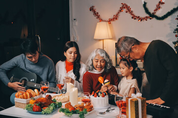Multi-Generation Family Celebrate Christmas At Home Wearing Santa Hats And Antlers Opening Presents