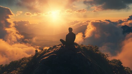 Silhouette of a man sitting on a rock with sunset and clouds in the background