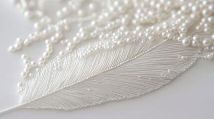 56.Single feather applique with intricate beadwork, crafted in all white with a length of 10-12 inches; the featherâ€™s delicate embroidery includes seed beads and pearls, showcasing meticulous
