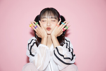 ピンク背景で撮影をしたスポーティな服装をした若い女性のキュートなポートレート