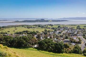 MANGERE MOUNTAIN, AUCKLAND, AUCKLAND, NEW ZEALAND, Panoramic view of a rural landscape out to puketutu island in the Manukau Harbour. Pastures, a waterway, and residential areas are visible. 