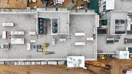 Construction site with a crane and a large building in the background. The crane is on the left side of the image and the building is on the right side.