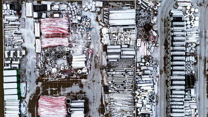 Large pile of white and red construction materials. The white materials are stacked on top of the red ones. An open warehouse of building materials, pipes, bricks, formwork wells and much more