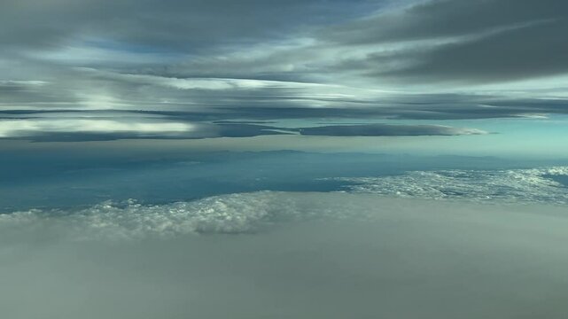 POV flying through a cold winter sky full of winding stratus clouds. Aerial footage taken from a jet cokpit flying at cruise. 4K 60FPS