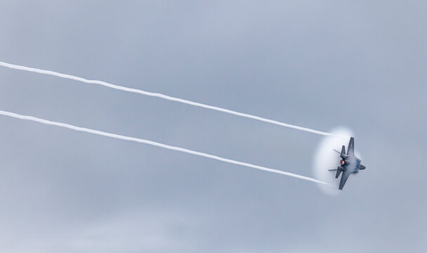 F-22 Raptor showing off its incredible speed and agility creating vivid contrails.