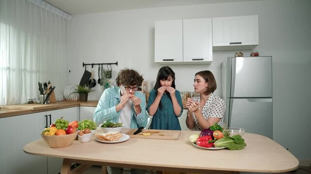 Happy caucasian father and mother sitting and eating fruit at modern kitchen. Energetic family spend time together by enjoy eating fruit or healthy fruit with kitchenware and fruit on table. Pedagogy.