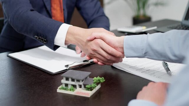 不動産の商談で握手をする男性