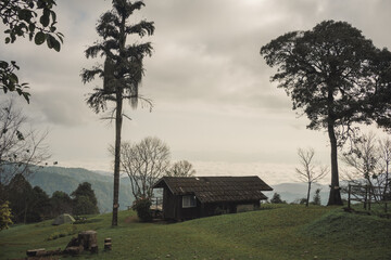 landscape and travel concept with sunrise and layer of mountain and mist with country house