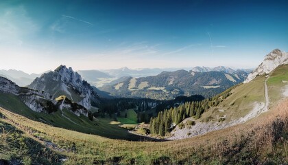 Fototapeta premium Panoramic view of snow-capped mountains with green meadows, forests, and a clear sky in the Alps