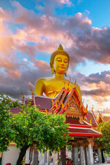 Obraz premium Big Buddha Dhammakaya Tep Mongkol Buddha of Paknam Bhasicharoen temple roof in Thonburi sunset clouds background.