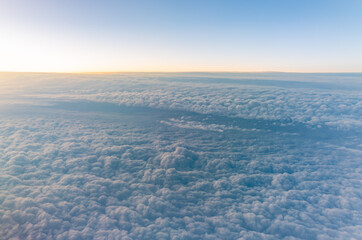 Beautiful orange and pink sunrise over the clouds, view from the plane.