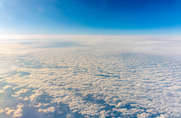 View from the airplane window at a beautiful cloudy sky and the airplane wing