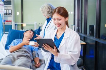 Obraz premium Two female doctors examine a patient lying on a hospital bed,discuss the medical chart,administer medicine,and provide encouragement, ensuring compassionate care and fostering the patient's recovery