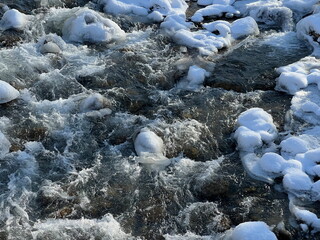 A river in a mountainous area in winter. A stormy stream.