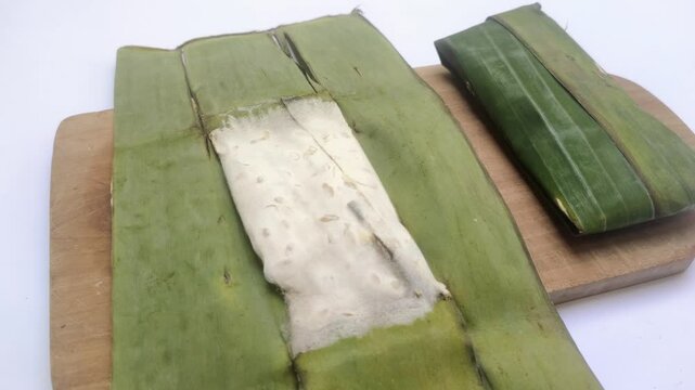 Traditional Indonesian Tempe Dish. Indonesian Tempe or fermented soybeans, the traditional food made by a fermentation soybeans covered in banana leaves on isolated white background.