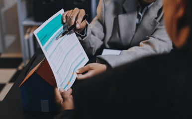 Close up Business people or Real Estate agent explain signing agreement for sale house to client. Property, Insurance, Broker concept.