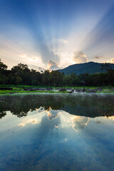Hot springs over rock terrain with misty and morning sunrise rays and Natural Mineral Water of Chae Son National Park in Lampang Province, Thailand.