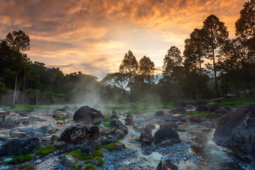 Hot springs over rock terrain with misty and morning sunrise rays and Natural Mineral Water of Chae Son National Park in Lampang Province, Thailand.