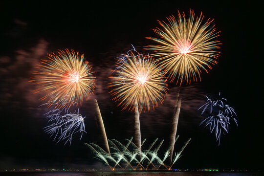 Multicolored Fireworks Exploding Over Water