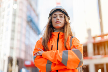 Proud woman construction professional worker in bright safety gear at an urban building site during the morning