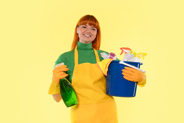 Woman cleaning with bright colors and a cheerful smile in a vibrant yellow environment