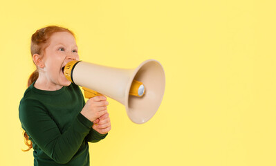 Child enthusiastically using a megaphone against a bright yellow background