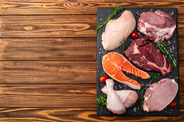 Mix of raw meat and fish . Salmon , beef , pork , chicken staek . Top view