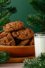 Christmas oatmeal cookies with chocolate in a bowl and milk in a glass