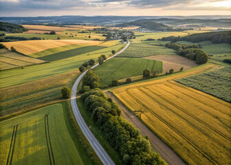 Fototapeta premium landscape with a road in the background, Drone View of Agricultural Fields with Country Road in a Picturesque Farm Landscape