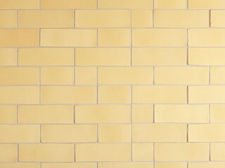 Obraz premium Yellow natural sandstone tiles stitched with clay creating seamless wall background, clay
