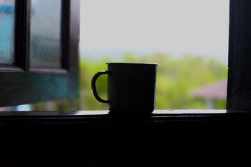 cup of coffee on window, Silhouette of a cup in the window with a beautiful view in the background