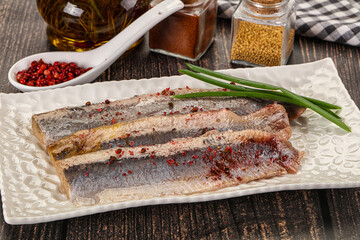 Salted marinated herring fillet with spices