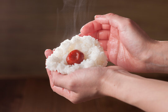 Hands gripping ume rice balls