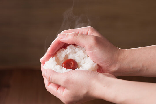 Hands gripping ume rice balls