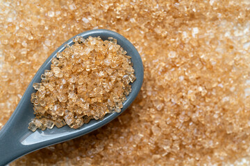 Close up of brown sugar with spoon texture and background, food and healthy concept