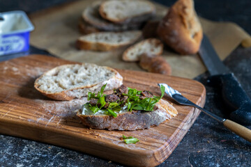 sliced bread on cutting board, ready to make open-faced sandwich