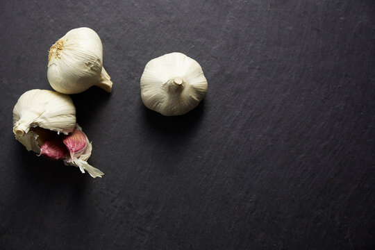 Purple garlic on a black stone baking tray