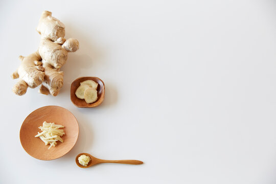 Various ginger on white baking plates and spoons