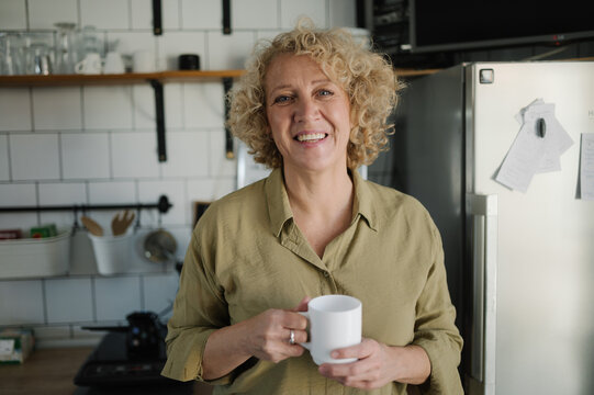 Smiling middle-aged woman in the kitchen looking at the camera.