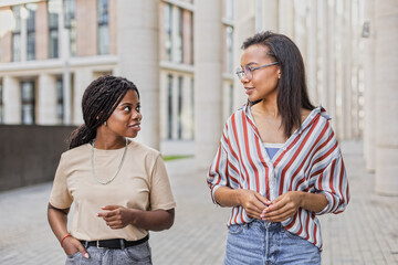 African American and Latin girls friends walking and chatting