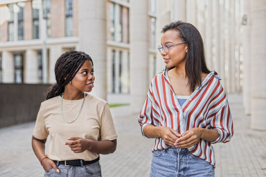 African American and Latin girls friends walking and chatting