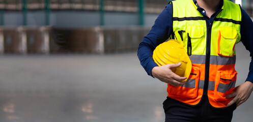 Safety hard haet helmet workwear for engineering building construction architect worker. Asian man Warehouse staff Employees worker standing by goods shelf working in large warehouse