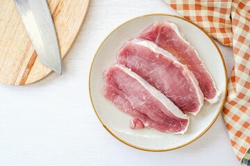 Sliced  pork in ceramic plate on a white background, top view