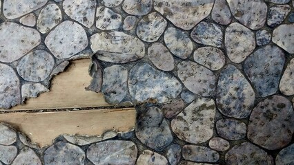  a section of a wall or floor with a stone-like pattern. The pattern consists of irregularly shaped stones in various shades of grey, resembling a cobblestone surface