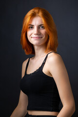 Fototapeta premium Cute red-haired girl, studio portrait on a black background.