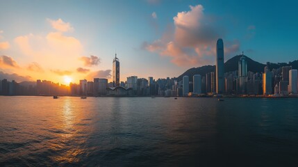 Obraz premium Hong Kong Sunset Skyline: Golden hour paints the Hong Kong cityscape in vibrant hues, as the sun dips below the horizon, casting a warm glow on skyscrapers and the tranquil waters of Victoria Harbour.