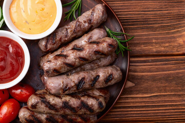 Grilled beef sausages with rosemary sauce and tomatoes photography . Top view
