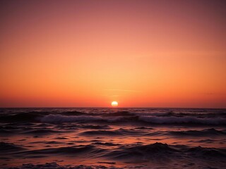 Fototapeta premium Sunset over the ocean with golden light on waves, ocean scenery, sunset ocean, sky and sea
