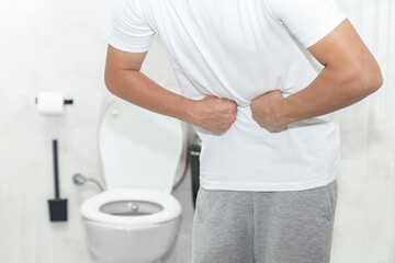 Men have stomachache and use their hands to hold their stomach In the bathroom. Constipation or...