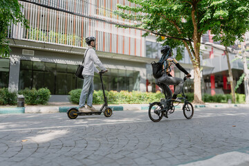 Commuting to work with bicycle. Young business person cycling and riding electric scooter to office in downtown district. Modern diversity people use eco transportation in city. Sustainable lifestyle. © Nassorn